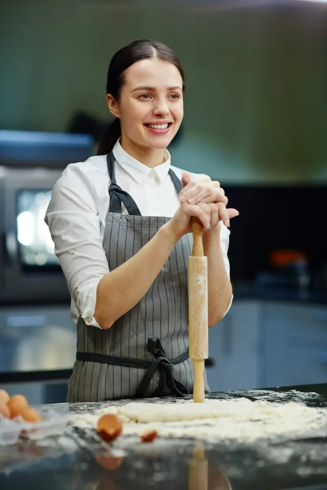 Une pâtissière souriante au rouleau